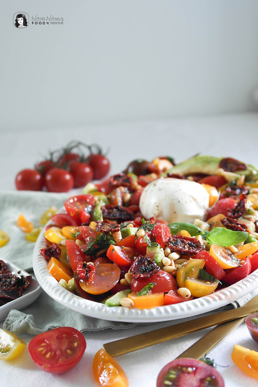 Tomaten-Avocado-Salat mit knusprigen Tomaten-Chips, Burrata und Pinienkernen